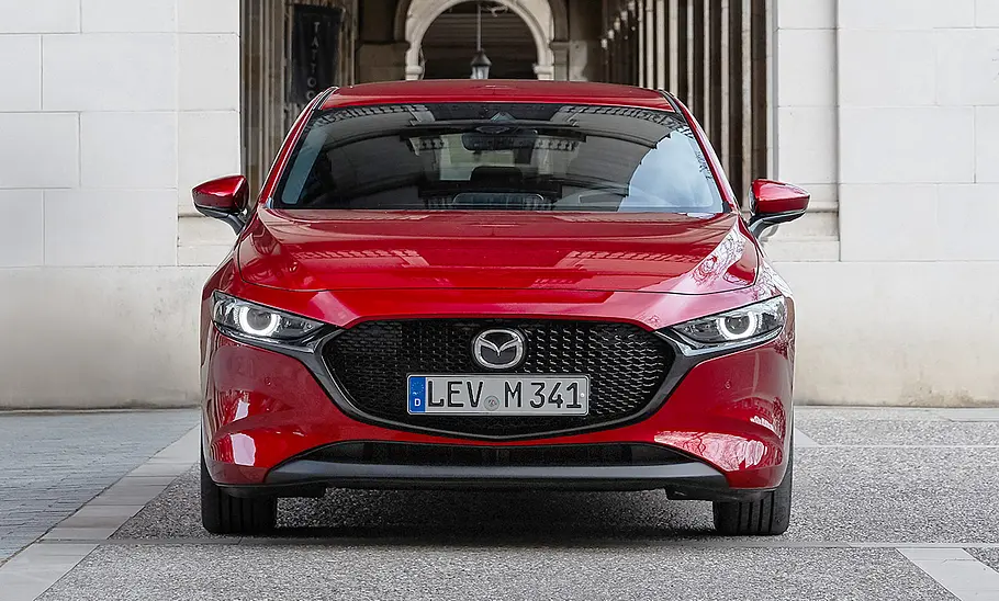 Mazda3 (2019) Der Mazda3 (2019) steht vor einem historischen Bauwerk. Von vorne fotografiert