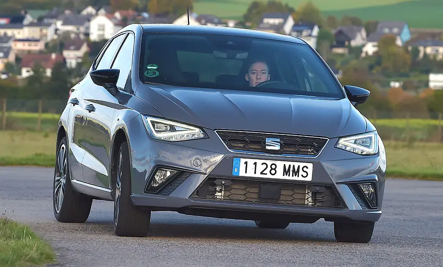 Der Seat Ibiza fährt durch eine Rechtskurve, von vorne fotografiert.