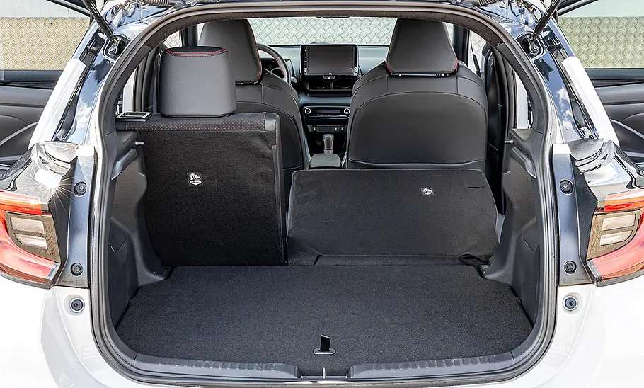 Im Kofferraum des Toyota Yaris (2020) sind zwei Rücksitzlehnen umgeklappt. Durch die geöffnete Heckklappe fotografiert