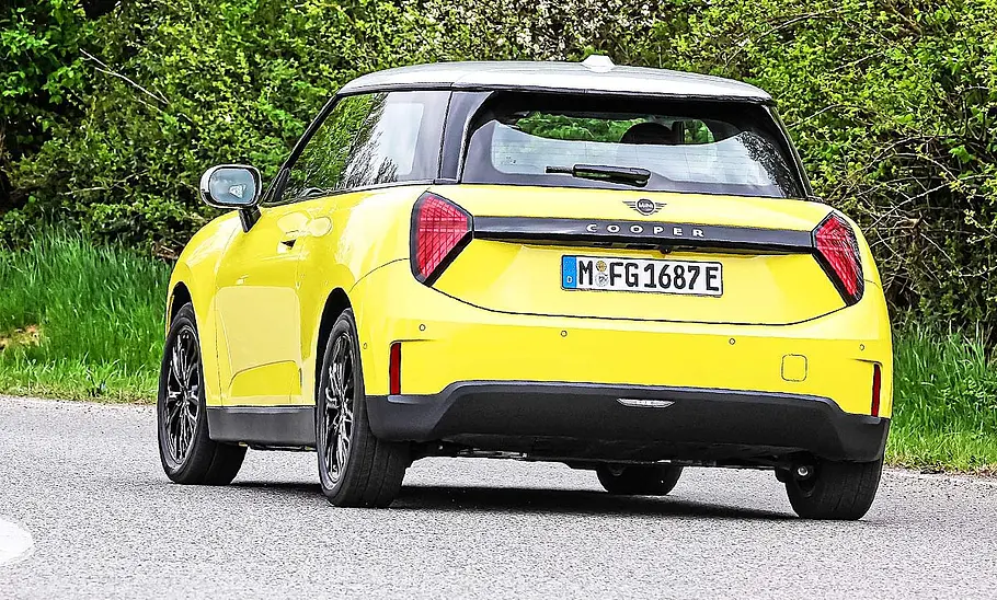 Blick von schräg hinten auf den fahrenden Mini Cooper E.