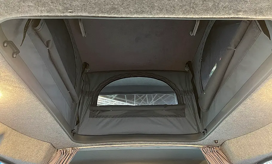 Alpincamper Maxus eDeliver 5 (2025) Die Innenaufnahme zeigt das geöffnete Aufstelldach des Alpincamper Maxus eDeliver 5 (2025).