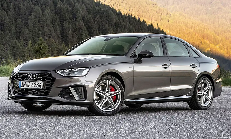 Der Audi A4 (2019) steht vor einem Waldpanorama, von vorne links fotografiert.