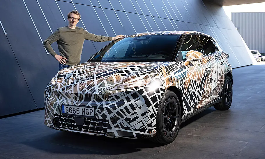 Redakteur Max Grigo steht neben dem getarnten Cupra Raval (2026).
