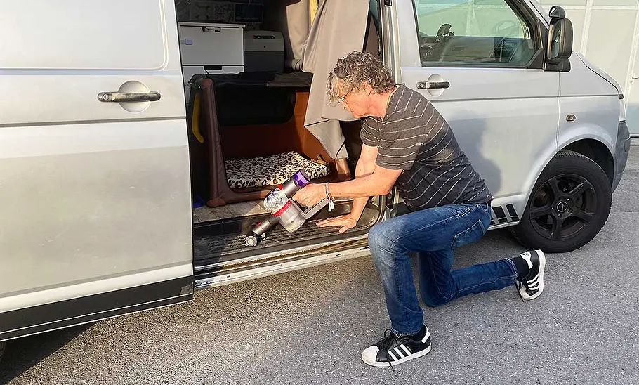 Das Bild zeigt einen Tester beim Absaugen der Trittschwelle der Seitentür eines VW Bus mit dem Dyson Akku-Staubsauger Car & Boat V8.