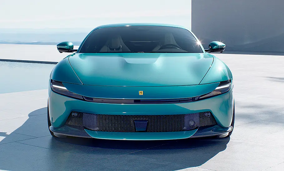 Ferrari Amalfi (2025) Der Ferrari Amalfi (2025) steht auf gefliestem Boden vor einem Haus, von vorne fotografiert.