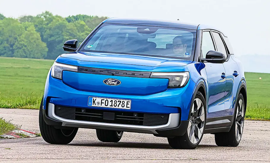 Ford Explorer Elektro Blick von schräg vorne auf den fahrenden Ford Explorer Elektro, der zügig eine enge Kurve passiert.