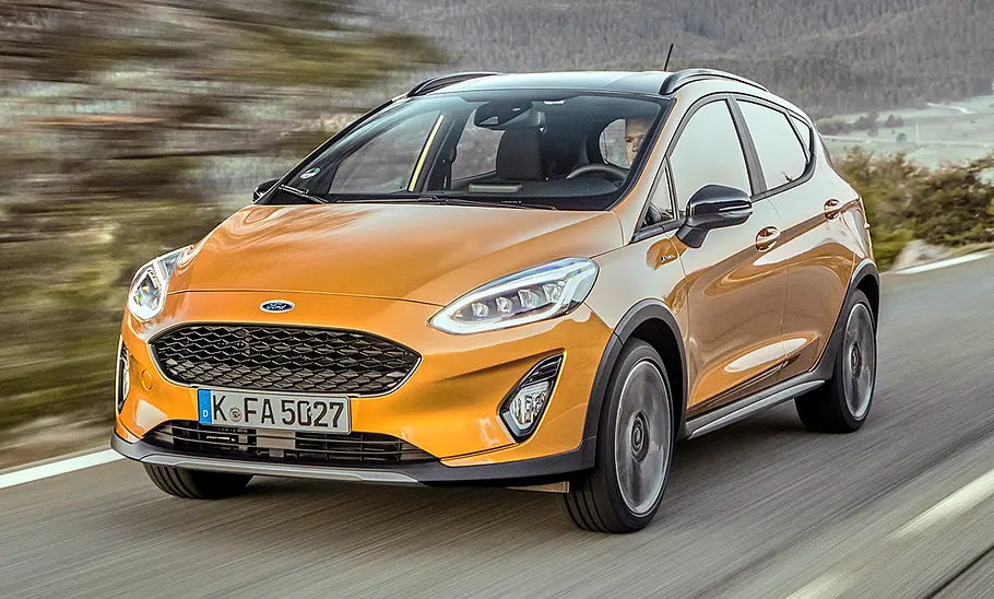 Der Ford Fiesta Active (2017) fährt vor Küstenpanorama eine Straße entlang, von vorne links fotografiert.
