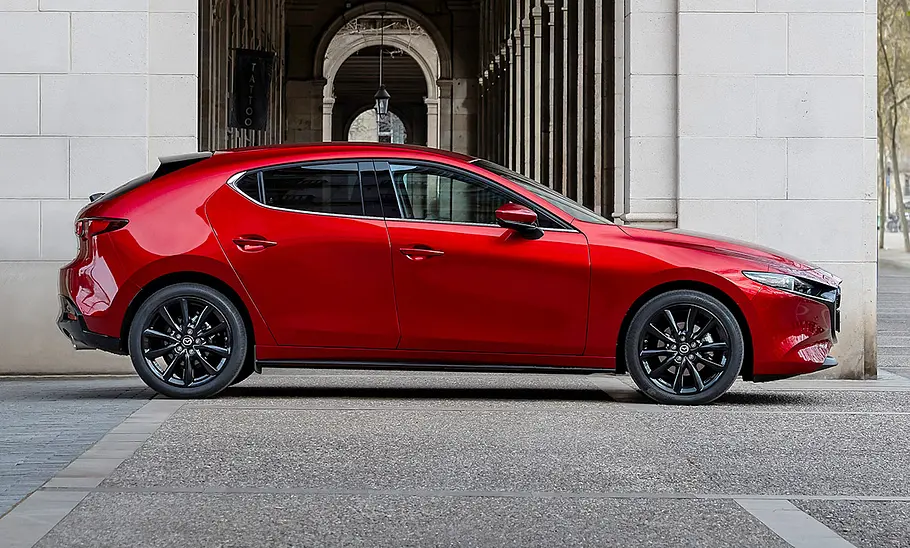 Mazda3 (2019) Der Mazda3 (2019) steht vor einem historischen Bauwerk. Von der rechten Seite fotografiert