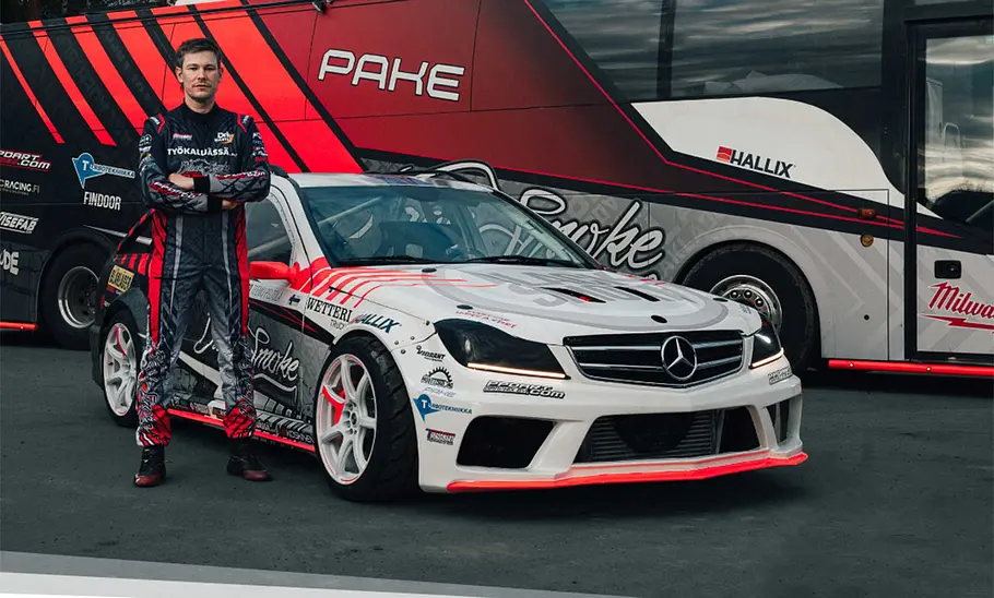 Teemu Peltola mit getuntem Mercedes S203 vor dem Teambus von Black Smoke Performance.