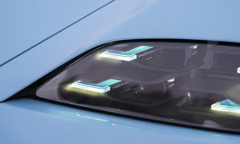 Der linke Scheinwerfer des Porsche Taycan 4 Facelift (2025) in der Detailaufnahme.