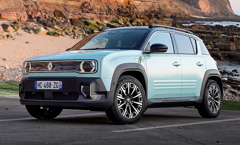 Der Renault 4 E-Tech Electric (2025) steht vor einem Felspanorama, von vorne links fotografiert.