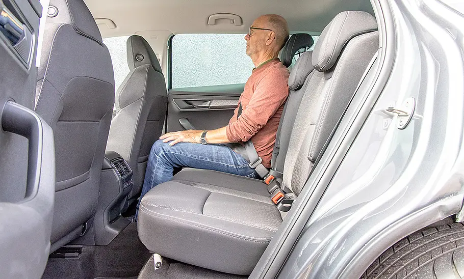 Ein Mann sitzt im Fond des Skoda Karoq.