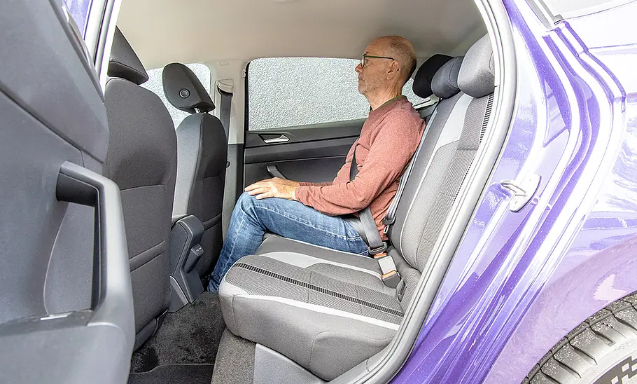 Ein Mann sitzt im Fond des VW Polo.
