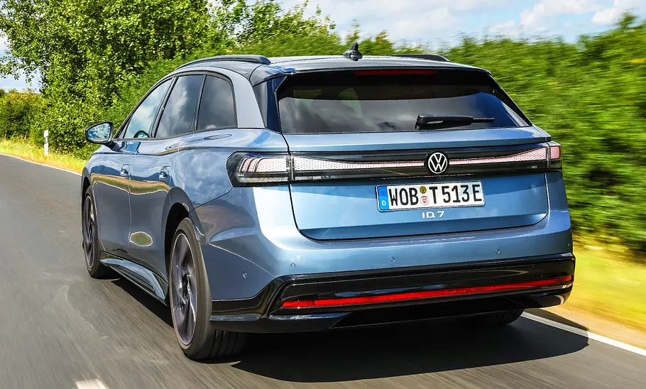 VW ID.7 Tourer Pro VW ID.7 Tourer Pro fährt auf einer Landstraße, Ansicht von hinten.