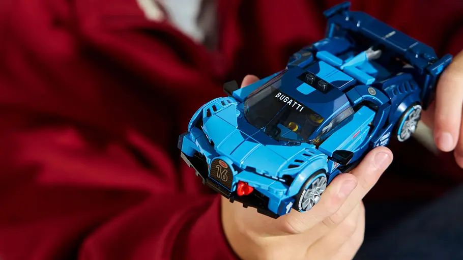 Lego Speed Champions Bugatti Vision Gran Turismo Kinderhände halten den Bugatti Vision Gran Turismo von Lego Speed Champoins.