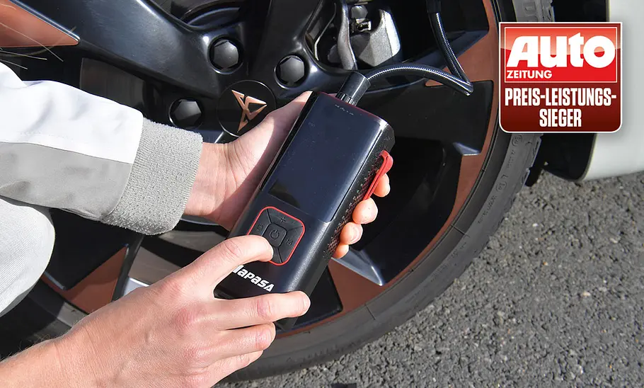 Testerhände mit Napasa Car Air Pump ATJ-6988, fotografiert von der Seite. Akku-Luftpumpe Napasa Car Air Pump ATJ-6988 im Test