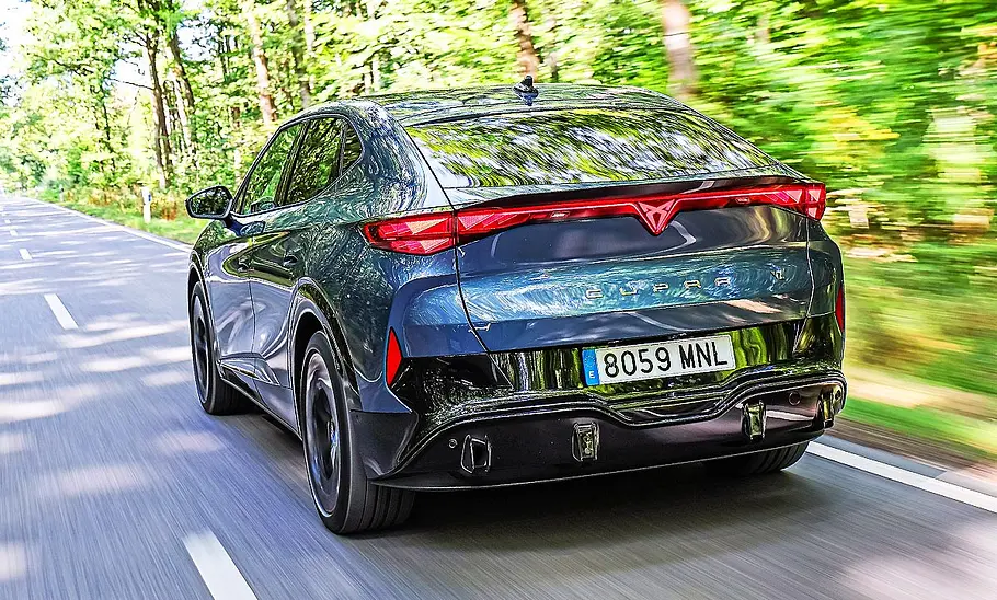 Blick von schräg hinten auf den fahrenden Cupra Tavascan VZ.