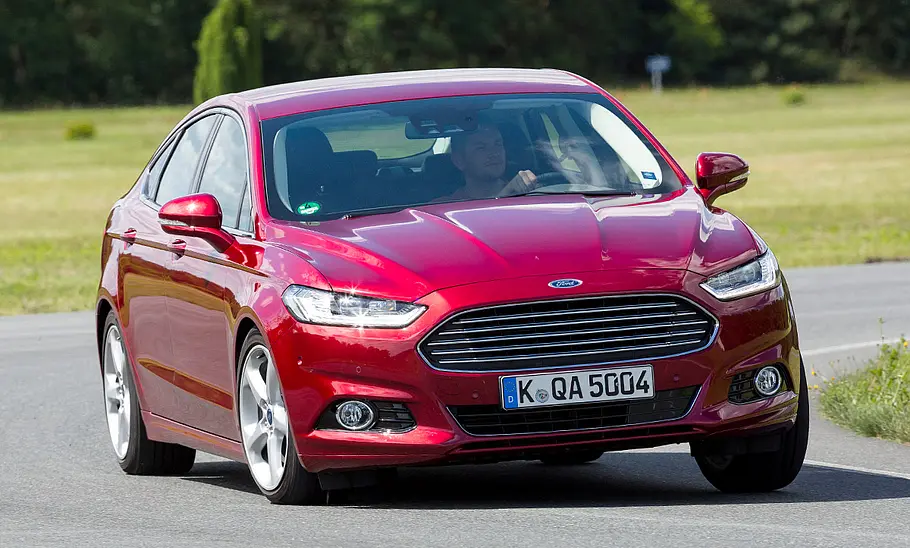 Ford Mondeo (2015) Der Ford Mondeo (2015) fährt durch eine Linkskurve, von vorne rechts fotografiert.