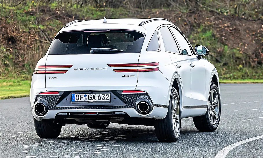 Genesis GV70 Blick von schräg hinten auf den fahrenden Genesis GV70.