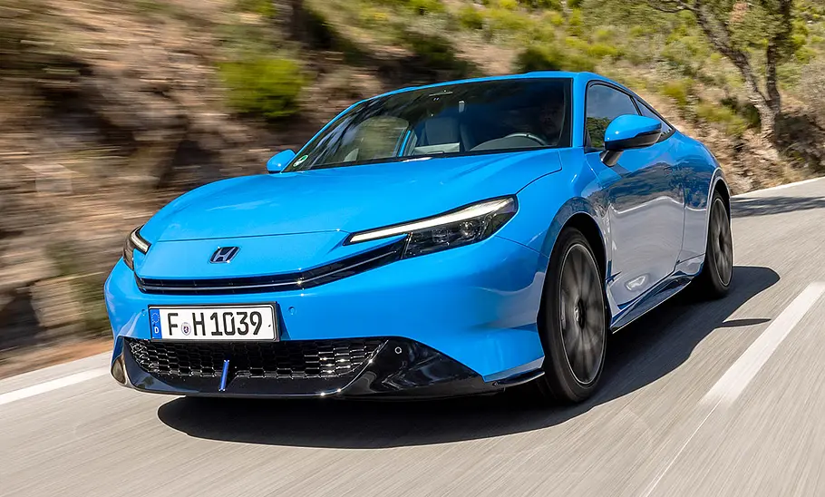 Der Honda Prelude (2026) fährt auf einer Landstraße, von vorne links fotografiert.