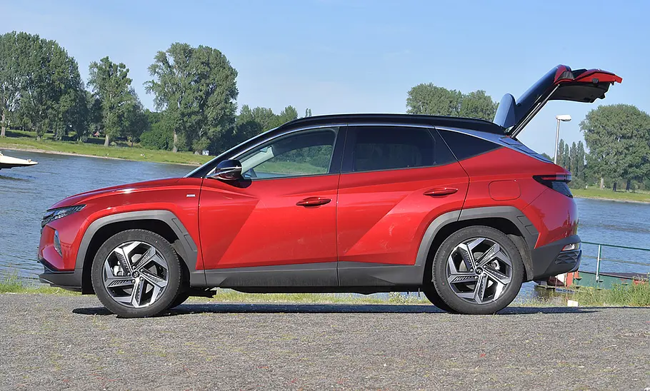 Hyundai Tucson (2020) Der Hyundai Tucson (2020) steht an einem Flussufer, mit geöffneter Heckklappe von links fotografiert.