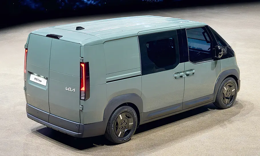 Kia PV5 Crew (2025) Der Kia PV5 Crew (2025) steht in Studioumgebung, von hinten rechts fotografiert.