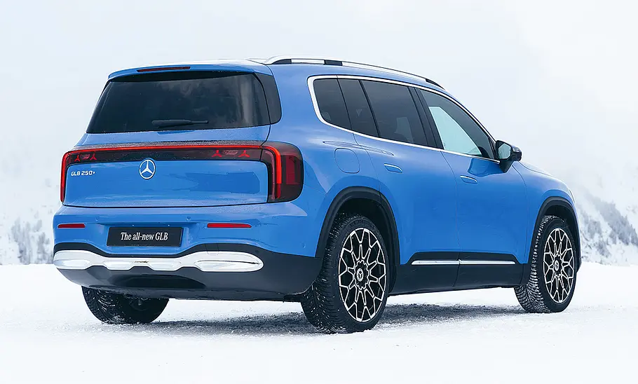 Mercedes GLB EQ Der Mercedes GLB EQ steht auf Schnee, von hinten rechts fotografiert.