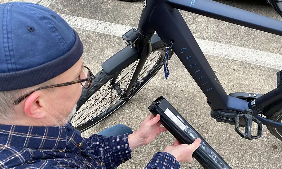 Test-Redakteur beim Demontieren des Akkus eines E-Bikes.