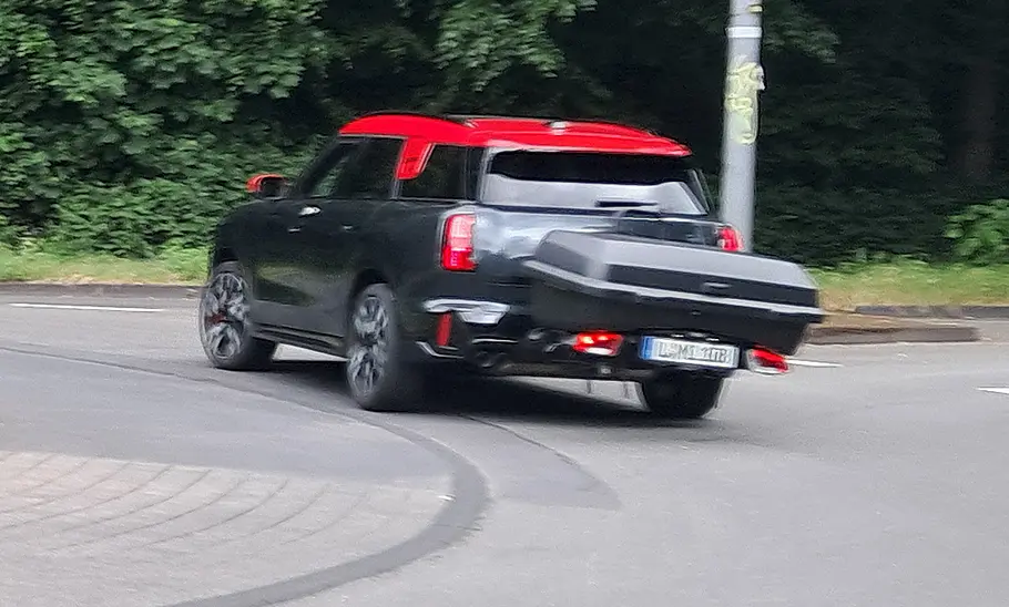 Kurvenfahrt im Kreisverkehr mit dem Mini Countryman und der Heckbox Thule Santu im Test, fotografiert von hinten.