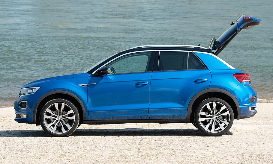 VW T-Roc (2017) Der VW T-Roc (2017) steht mit geöffneter Heckklappe am Wasser, von links fotografiert.