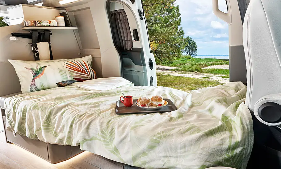 Das durch umklappen der Sitzlehnen entstandene Bett im Westfalia Kelsey (2024).