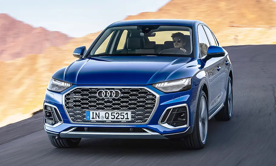 Der Audi Q5 Sportback (2020) fährt über eine Straße in den Bergen, von vorne fotografiert.
