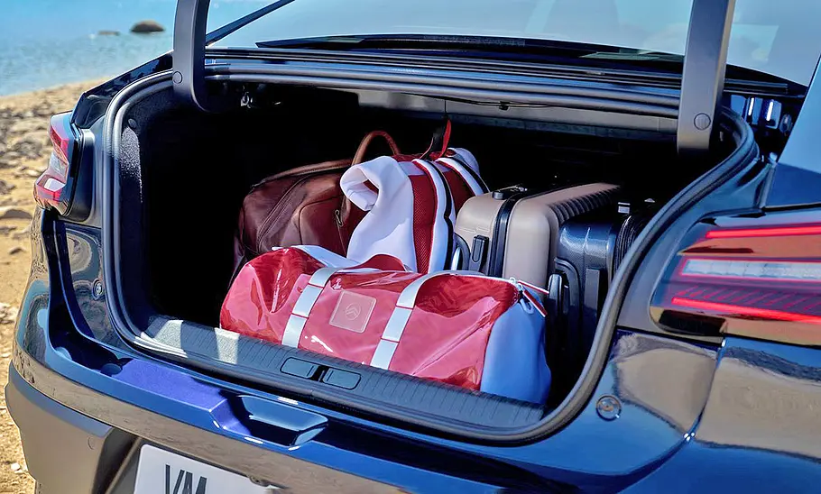 Citroën ë-C4 X Facelift (2025) Der Kofferraum des Citroën ë-C4 X Facelift (2025) mit geöffneter Klappe und Taschen im Gepäckraum.