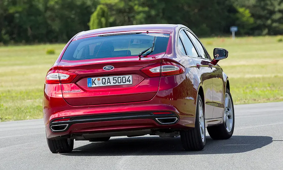 Ford Mondeo (2015) Der Ford Mondeo (2015) fährt durch eine Rechtskurve, von hinten fotografiert.