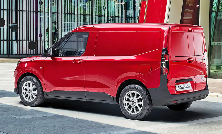 Der Ford Transit Courier (2024) steht in urbaner Umgebung, von hinten links fotografiert.