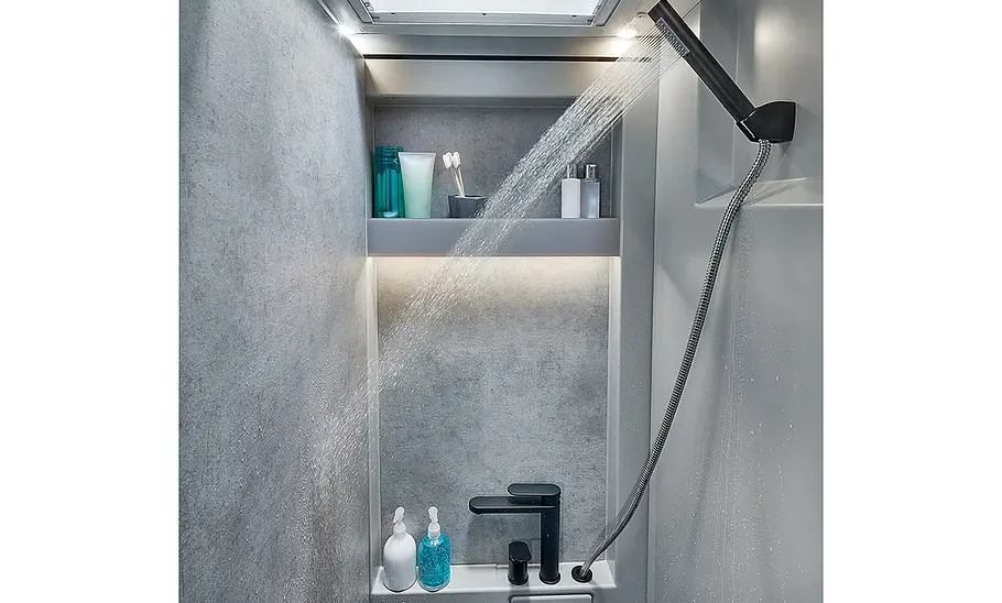 Dusche des Niesmann + Bischoff iSmove (2024), Ansicht auf die Ablage, Armaturen und den Duschkopf rechts oben.