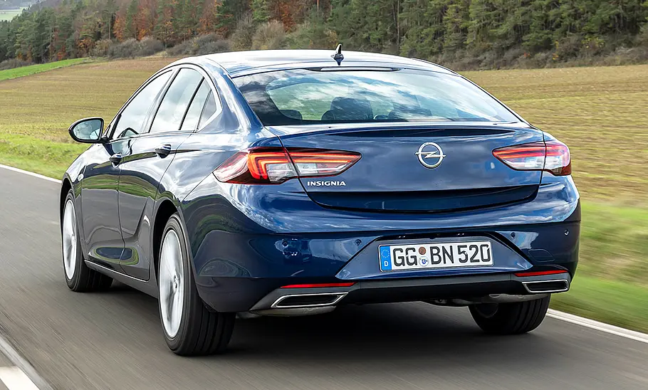 Der Opel Insignia (2020) fährt eine Straße entlang, von hinten links fotografiert.