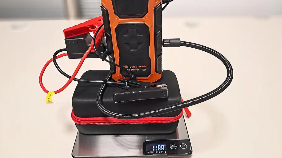 Die Featoo Starthilfe Powerbank im Test Die Featoo Starthilfe Powerbank steht mit Kabeln und Hülle auf einer Waage.