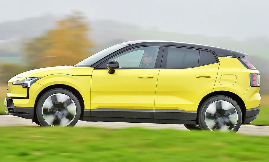 Blick von der Seite auf den fahrenden Volvo EX30.