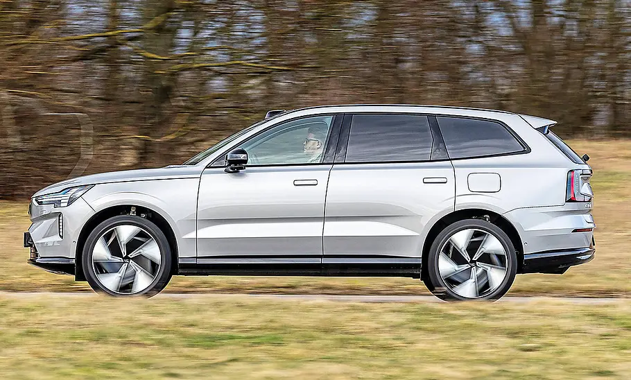 Blick von der Seite auf den fahrenden Volvo EX90.
