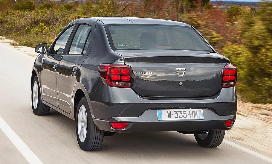 Der Dacia Logan (2016) als Limousine fährt auf einer Straße, von hinten rechts fotografiert.