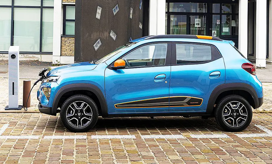 Der Dacia Spring stehend auf einer Straße von der Seite abgelichtet.