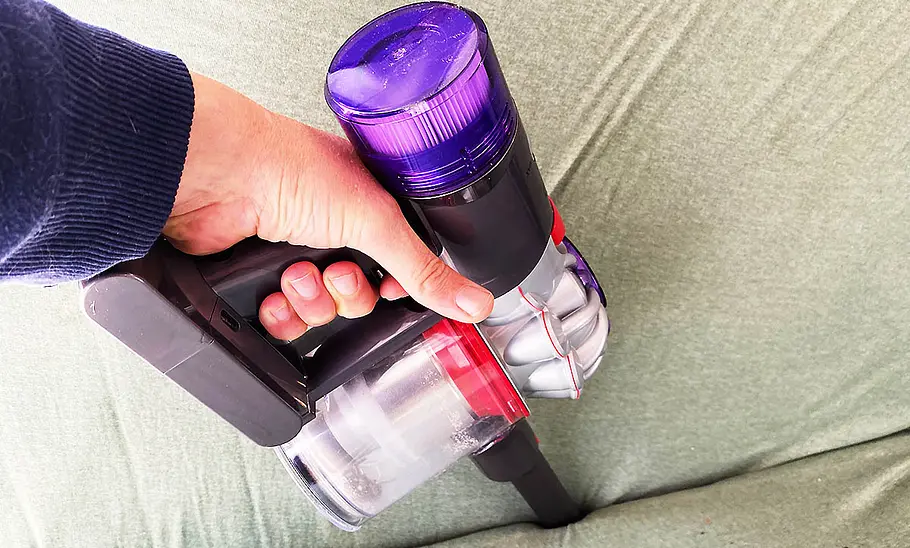 Die Detailaufnahme zeigt die Fugendüse des Dyson Akku-Staubsauger Car & Boat V8 beim Absaugen einer Bettritze.
