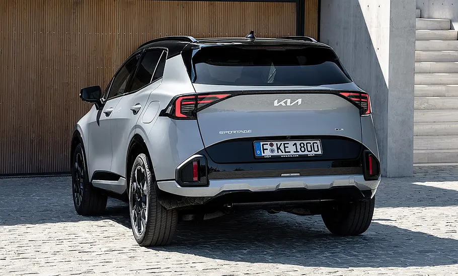 Kia Sportage (2025) Der Kia Sportage (2025) parkt vor einem Haus, von hinten fotografiert.