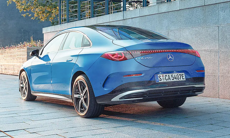 Der Mercedes CLA EQ (2025) steht auf einem Bürgersteig, von hinten links fotografiert.