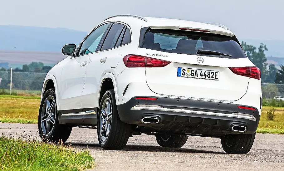 Mercedes GLA Blick von schräg hinten auf den fahrenden Mercedes GLA, der im sportlichen Fahrstil eine scharfe Kurve passiert.