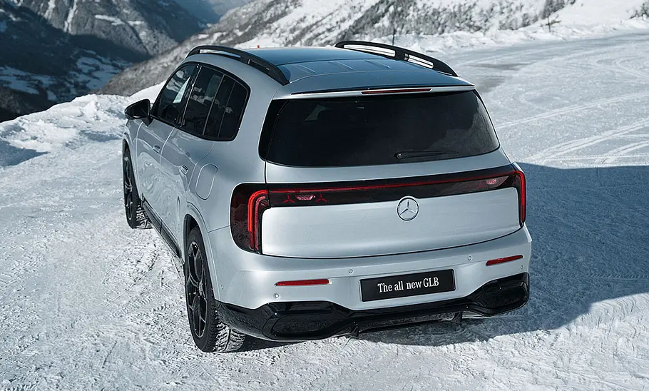 Der Mercedes GLB steht im Schnee, von hinten links fotografiert.