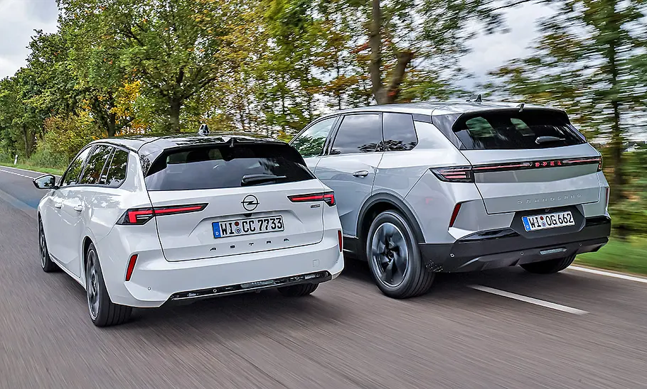 Blick von schräg hinten auf den Opel Astra Sports Tourer und Opel Grandland, die nebeneinander fahren.