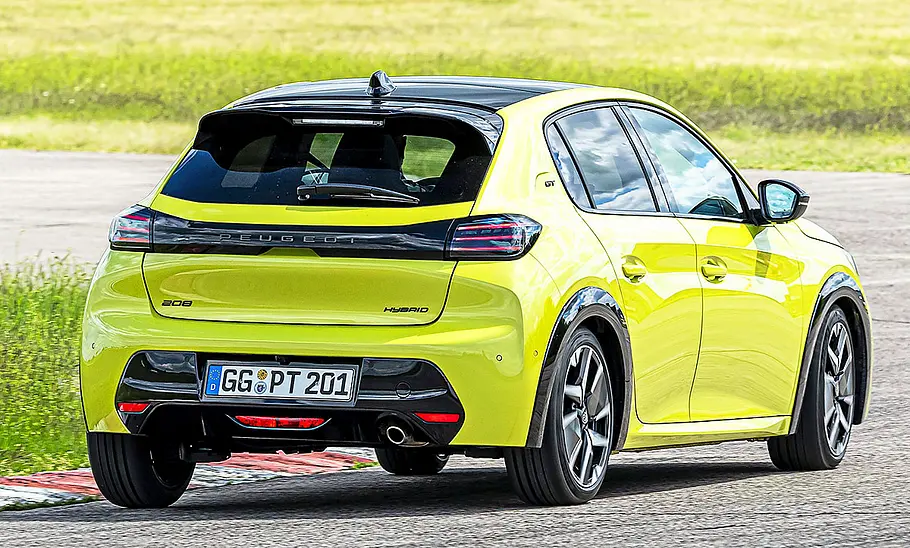 Blick von schräg hinten auf den fahrenden Peugeot 208.