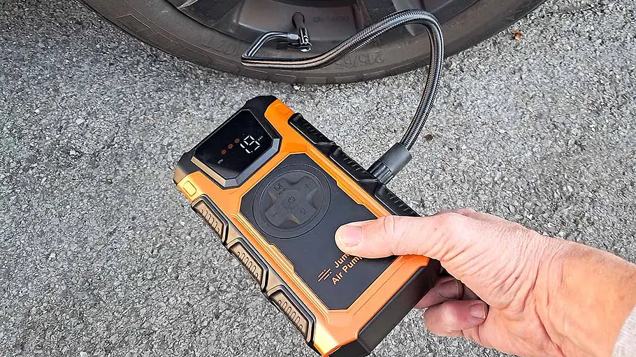 Die Featoo-Starthilfe-Powerbank im Test Die Featoo-Starthilfe-Powerbank der Hand eines Testers beim Aufpumpen eines Autoreifens.